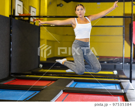 Young woman with children practicing and jumping in trampoline center 97535384