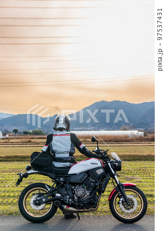 「埼玉県」旅先で夕陽を眺めるライダー 97537431