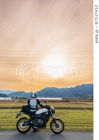 「埼玉県」旅先で夕陽を眺めるライダー 97537432