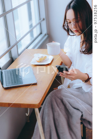 カフェでテレワークをしている若い女性の写真 97538256