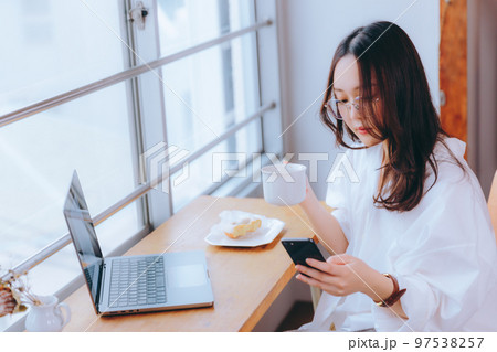 カフェでテレワークをしている若い女性の写真 97538257