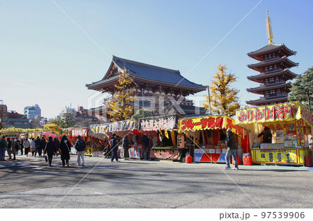 青空に映える浅草寺の五重塔、下界では立ち並ぶ露店に群がる人々 97539906