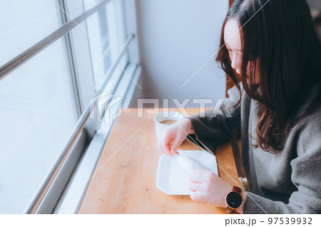 家でドーナツを食べる若い女性の写真 家でドーナツを食べる若い女性の写真 97539932