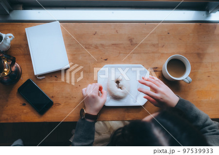 家でドーナツを食べる若い女性の写真 家でドーナツを食べる若い女性の写真 97539933