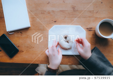 家でドーナツを食べる若い女性の写真 家でドーナツを食べる若い女性の写真 97539935