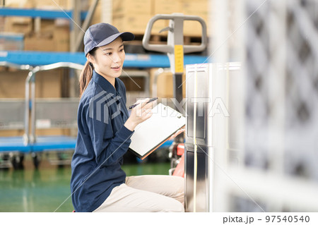 物流倉庫で働く若い女性の作業員 97540540