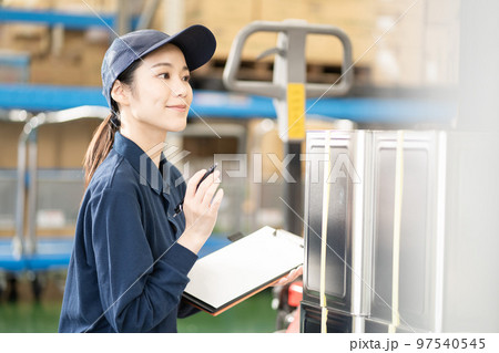 物流倉庫で働く若い女性の作業員 物流倉庫で働く若い女性の作業員 97540545