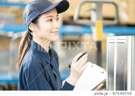 物流倉庫で働く若い女性の作業員 物流倉庫で働く若い女性の作業員 97540559