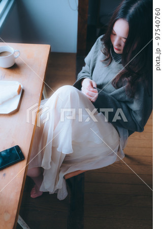 部屋で朝食を食べる若い女性の写真 97540760