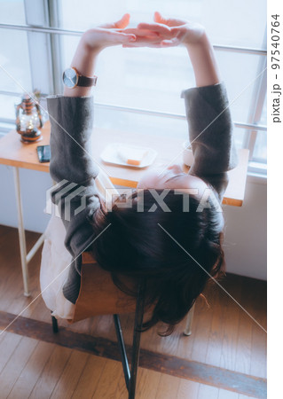 部屋で朝食を食べる若い女性の写真 97540764