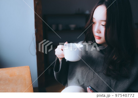 部屋で朝食を食べる若い女性の写真 97540772