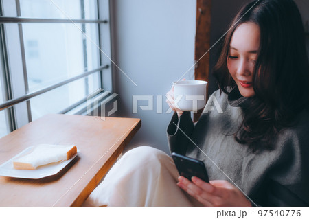 部屋で朝食を食べる若い女性の写真 97540776