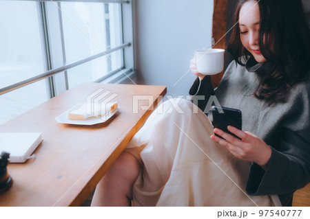 部屋で朝食を食べる若い女性の写真 97540777