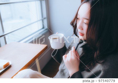 部屋で朝食を食べる若い女性の写真 97540779