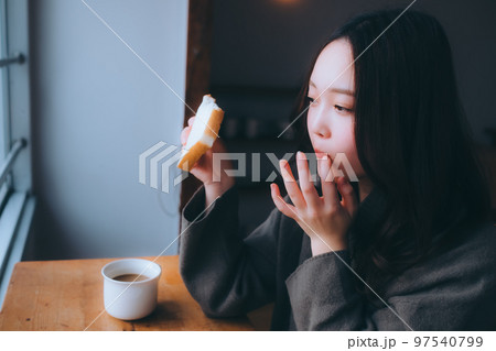 部屋で朝食を食べる若い女性の写真 部屋で朝食を食べる若い女性の写真 97540799