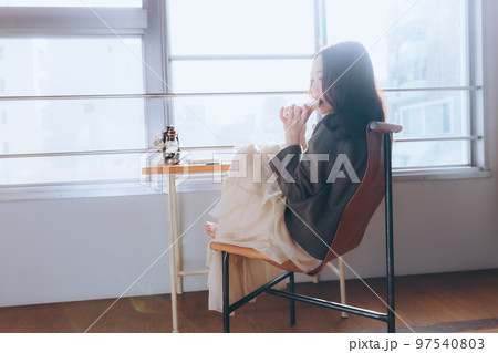部屋で朝食を食べる若い女性の写真 97540803