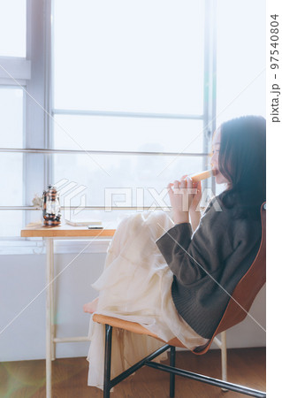 部屋で朝食を食べる若い女性の写真 97540804