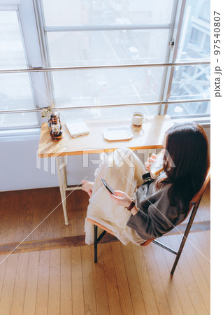 部屋で朝食を食べる若い女性の写真 97540807