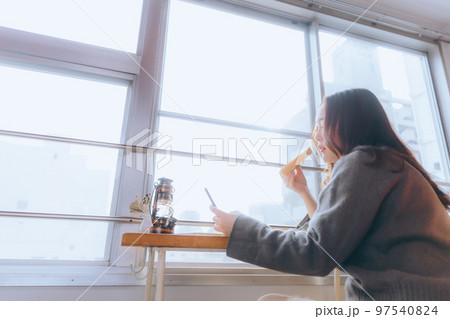 部屋で朝食を食べる若い女性の写真 部屋で朝食を食べる若い女性の写真 97540824