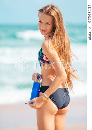 Happy young girl with sunblock on tropical beach vacation Happy young girl with sunblock on tropical beach vacation 97543152