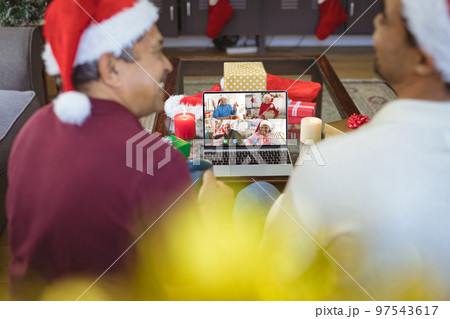 Senior biracial man and his adult son having christmas video call with diverse people Senior biracial man and his adult son having christmas video call with diverse people 97543617