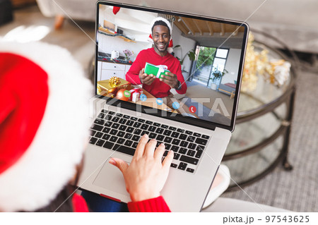 Caucasian woman having christmas video call with african american man Caucasian woman having christmas video call with african american man 97543625