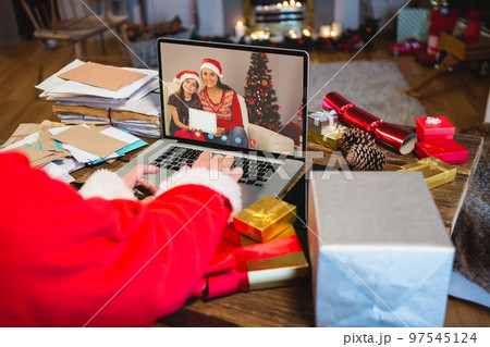 Santa claus with christmas presents having video call with happy caucasian family Santa claus with christmas presents having video call with happy caucasian family 97545124