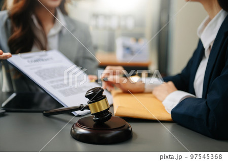 Male lawyer in the office with brass scale on wooden table. justice and law concept Male lawyer in the office with brass scale on wooden table. justice and law concept 97545368