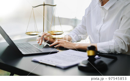 justice and law concept.Male judge in a courtroom  the gavel, working with smart phone and laptop and digital tablet computer on table 97545853