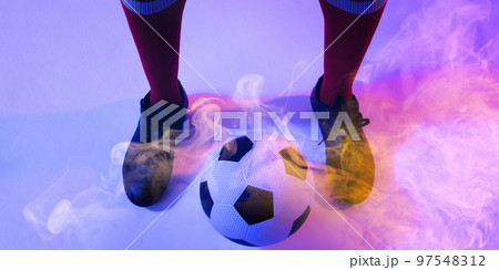 Low section of african american male player with ball standing on smoky background 97548312