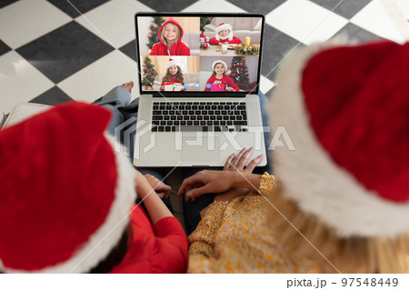Caucasian mother and daughter in santa hats on christmas laptop video call with caucasian children Caucasian mother and daughter in santa hats on christmas laptop video call with caucasian children 97548449