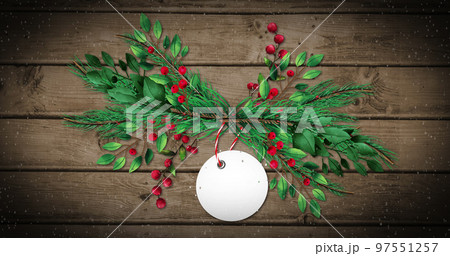 Image of snow falling and gift tag with copy space and tree branches on wooden background 97551257