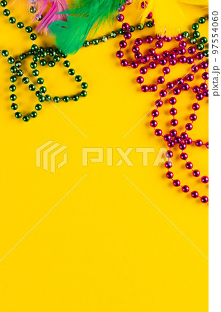 Composition of colourful mardi gras beads and feathers on yellow background with copy space Composition of colourful mardi gras beads and feathers on yellow background with copy space 97554060