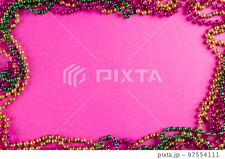Composition of colourful mardi gras beads on pink background with copy space Composition of colourful mardi gras beads on pink background with copy space 97554111
