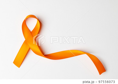 Close up of orange ribbon on white background with copy space 97556073
