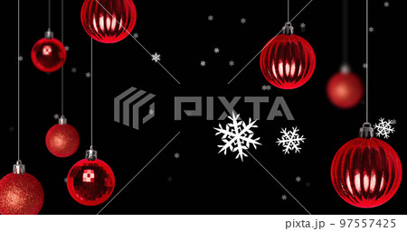 Snow falling over red baubles on black background 97557425