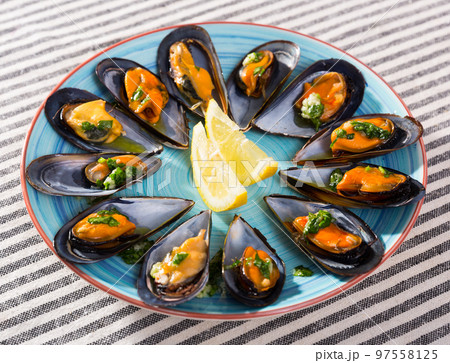 Photography of plate with mussels under lemon sauce Photography of plate with mussels under lemon sauce 97558125