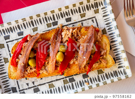 Toasts with canned tuna, anchovies, roasted pepper and olives 97558162