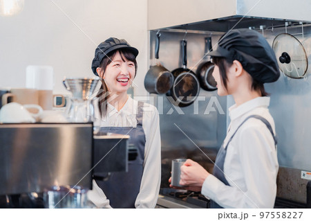 楽しく業務内容を教えてもらう飲食店アルバイトの女性 97558227