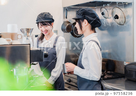 楽しく業務内容を教えてもらう飲食店アルバイトの女性 97558236