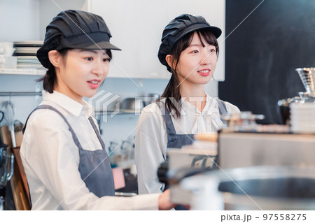 楽しく業務内容を教えてもらう飲食店アルバイトの女性 97558275