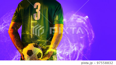 Rear view of soccer player holding ball with abstract neon in blue background, copy space 97558832