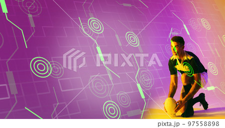 Caucasian rugby player placing ball on stand over illuminated circles and grid pattern Caucasian rugby player placing ball on stand over illuminated circles and grid pattern 97558898