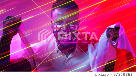 Portrait of african american soccer player with england flag screaming over long exposure of lights 97559863