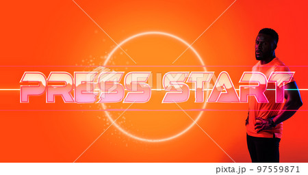 African american male athlete with hands on hip standing by press start text and circle, copy space 97559871