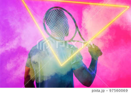 Rear view of african american male tennis player with racket amidst smoke by glowing triangle Rear view of african american male tennis player with racket amidst smoke by glowing triangle 97560069