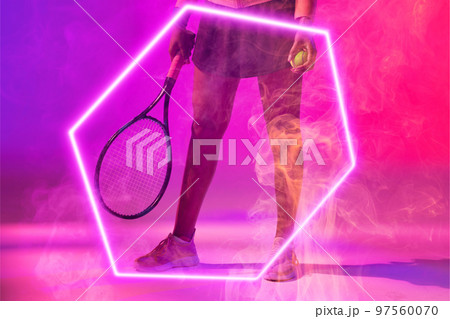 Low section of african american female tennis player holding ball and racket by glowing hexagon Low section of african american female tennis player holding ball and racket by glowing hexagon 97560070