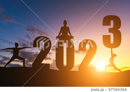 Happy New Year Numbers 2023, Silhouette woman practicing yoga early morning sunrise over the horizon background, Health and Happy new year concept. 97560368