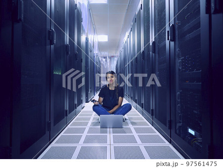 Portrait of female technician sitting on floor in server room 97561475
