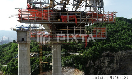 Aerial drone view on highway bridge road under construction. Construction of the viaduct on the modern new road. 97562387